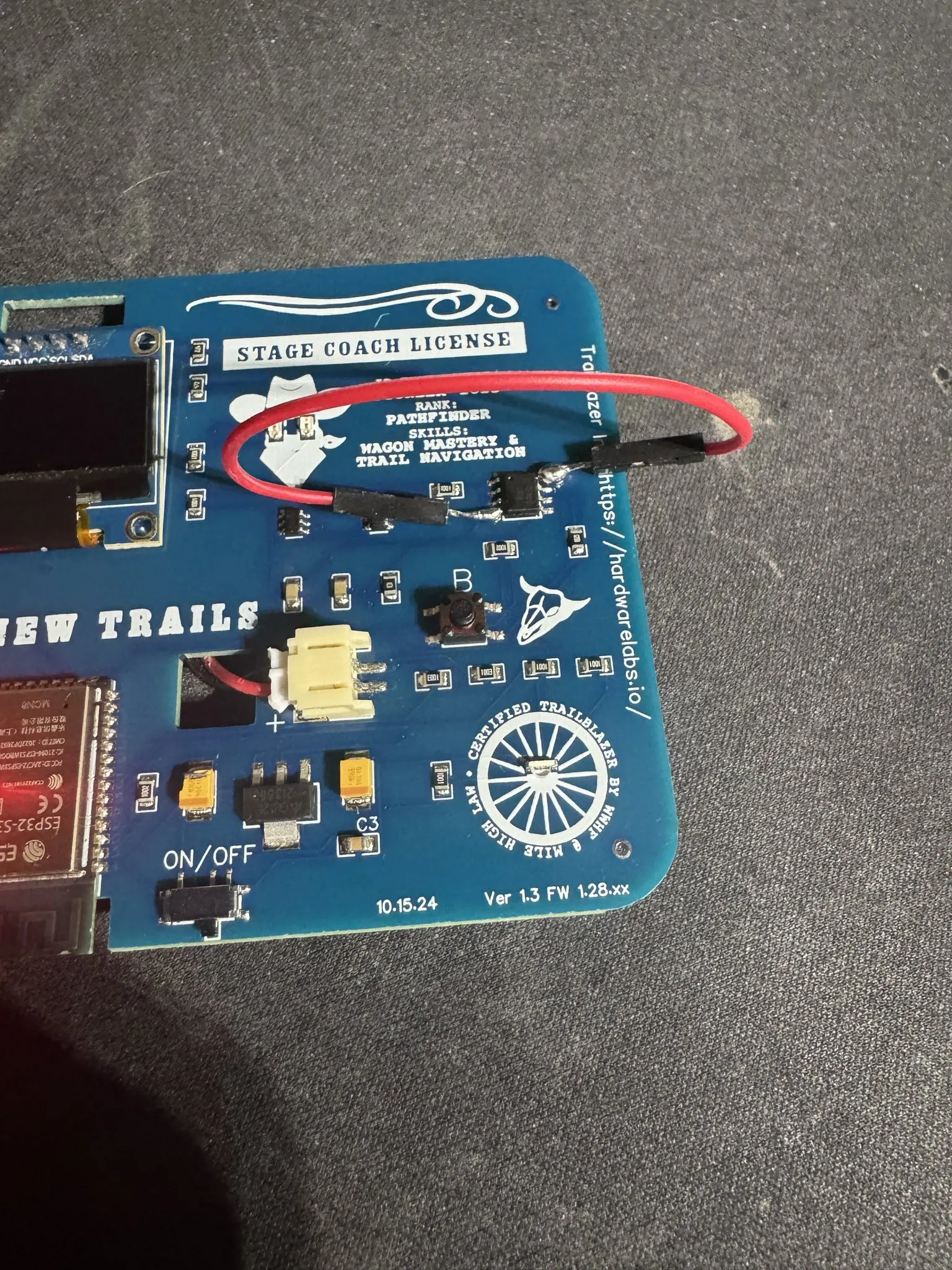 Mile High badge with a jumper wire soldered between pins 4 and 8 of the TP4056 charger chip